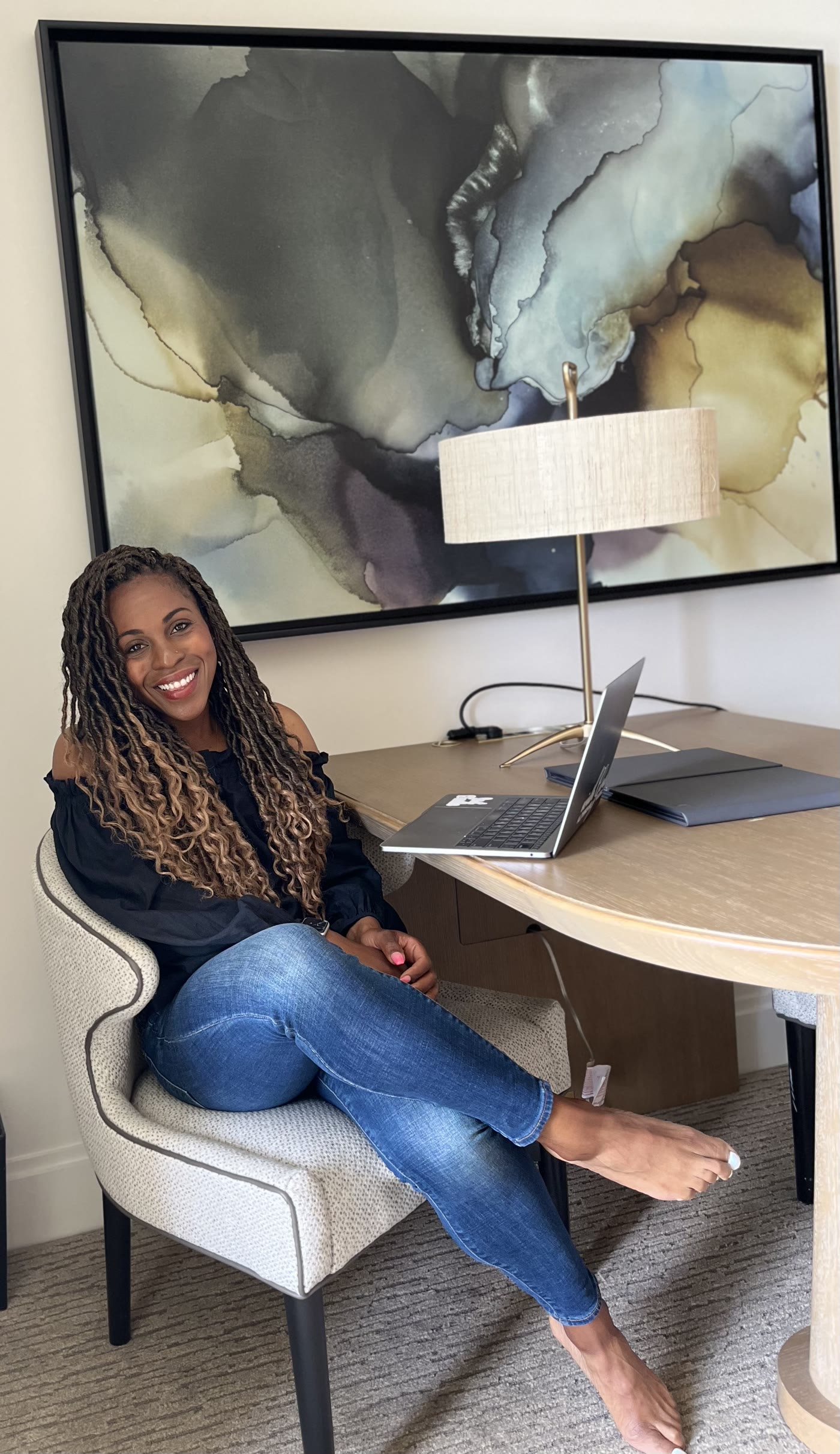 Coach Jo, founder of The Healthy Teachers Collective, seated at a table working on her laptop